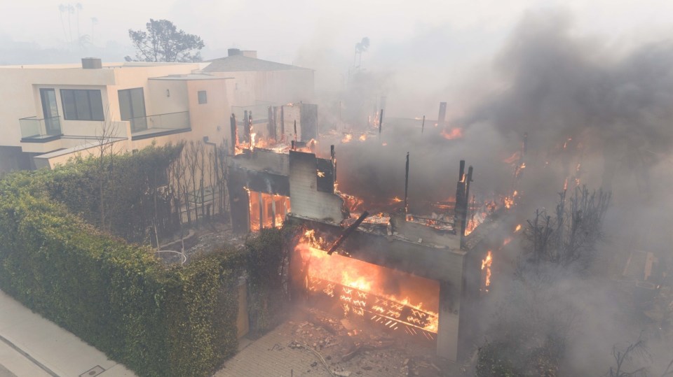 House engulfed in flames during wildfire.