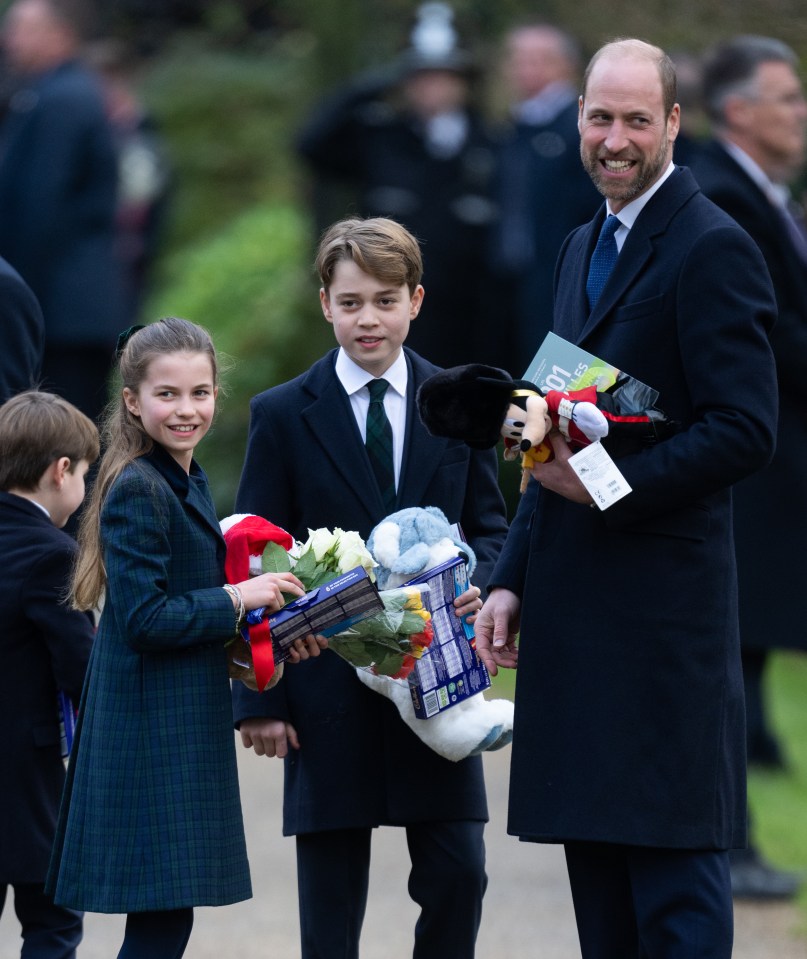 From left, Louis, Charlotte, George and dad Prince William hold presents given by crowds in Norfolk last month