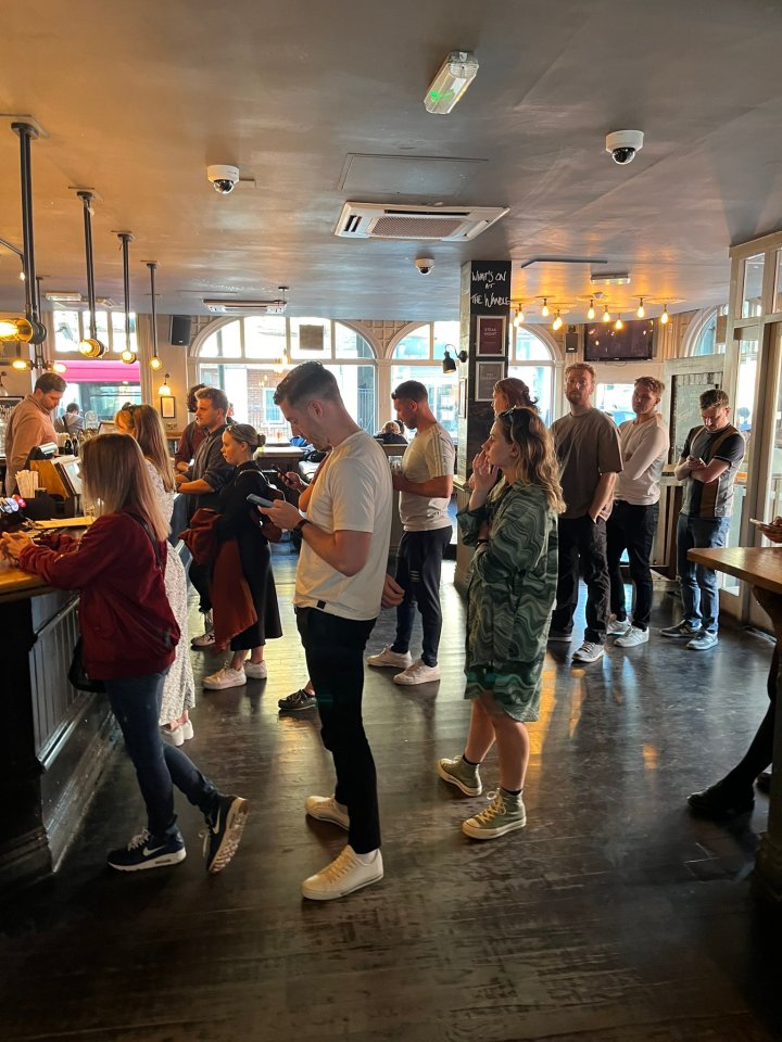 People queuing at a pub bar.