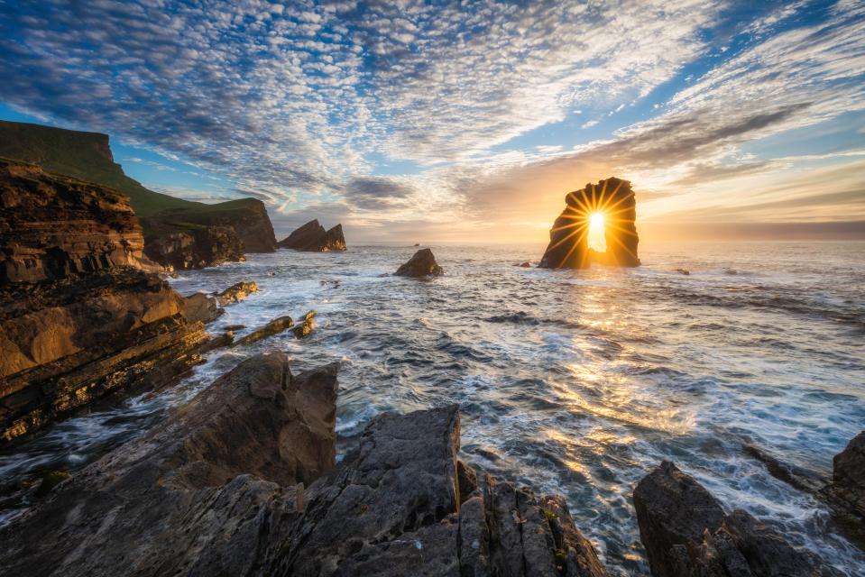 Sunset through a rock arch on the Isle of Foula.