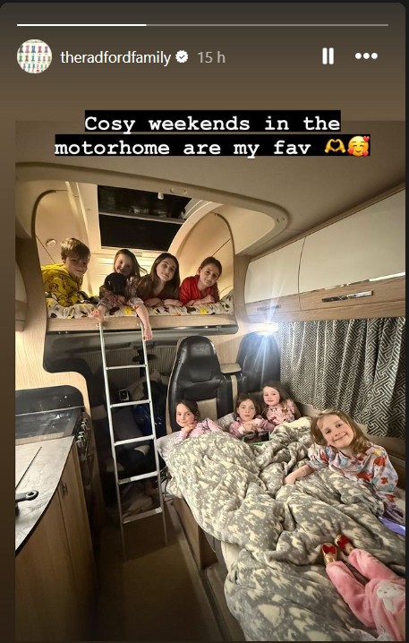 Several children in pajamas in a motorhome bunk bed.