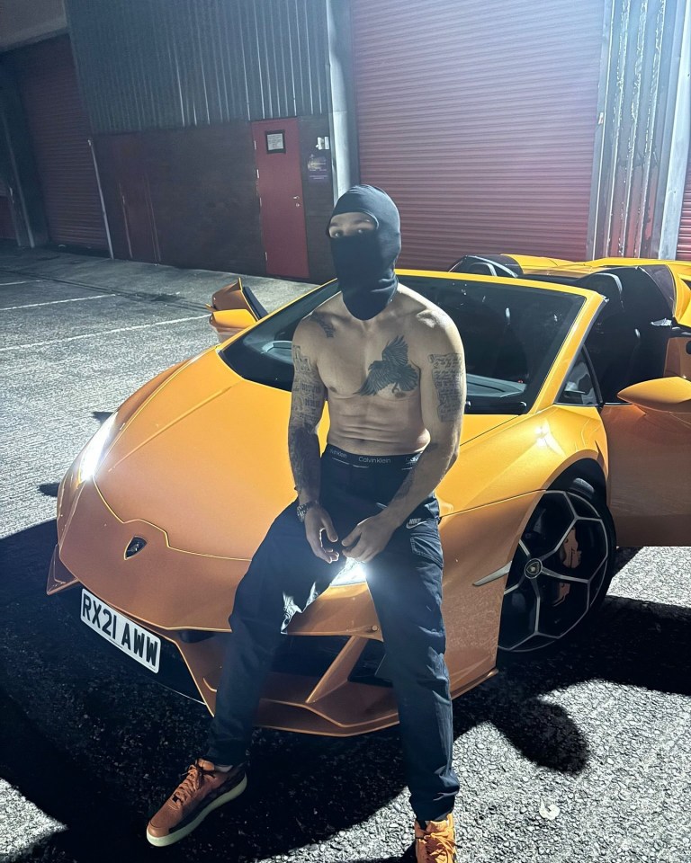 Rapper Ten1 aka Jake Fahri sitting in front of an orange Lamborghini.