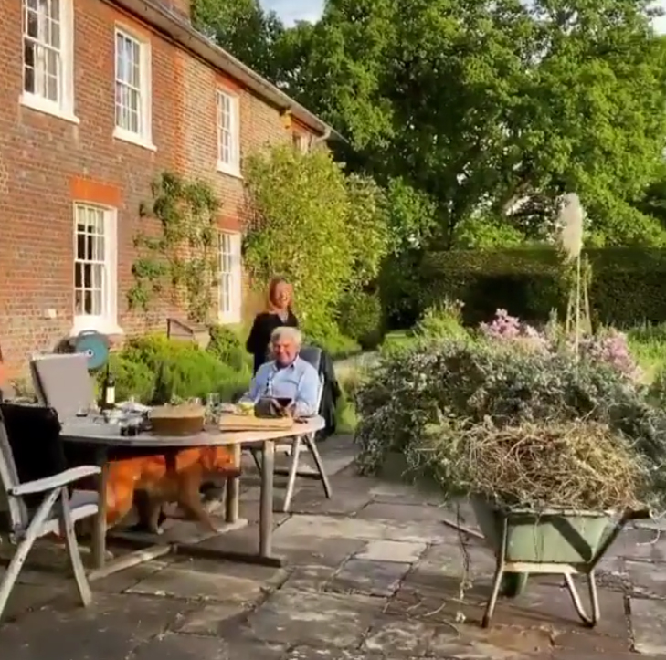 Kate Middleton's parents seated at an outdoor table in their backyard.