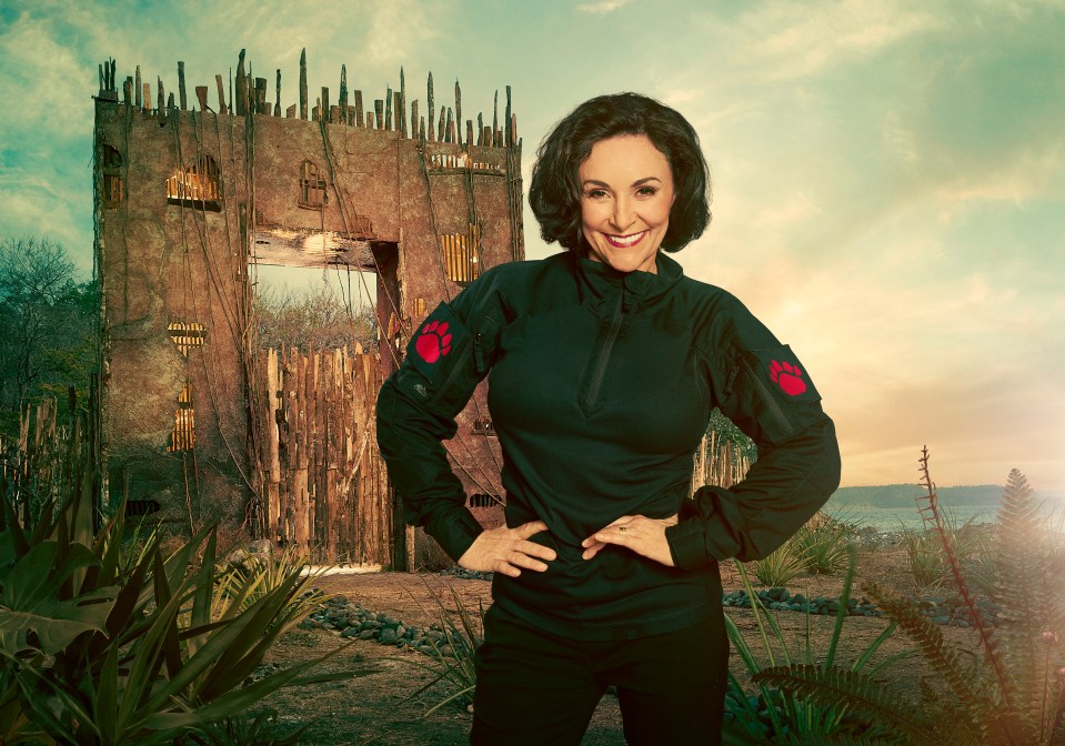 Shirley Ballas, contestant on Celebrity Bear Hunt, standing before a dilapidated gate.