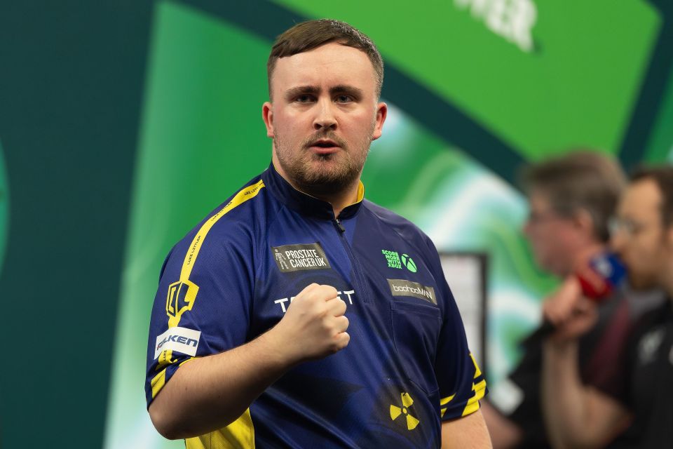 Luke Littler celebrates during a darts match.