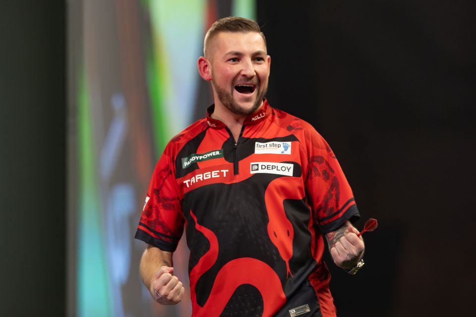 Nathan Aspinall celebrating during a darts match.