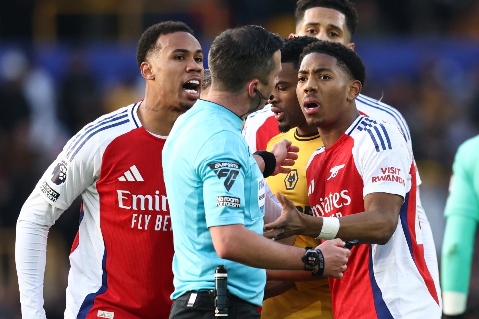 Arsenal player reacts to being sent off by a referee.