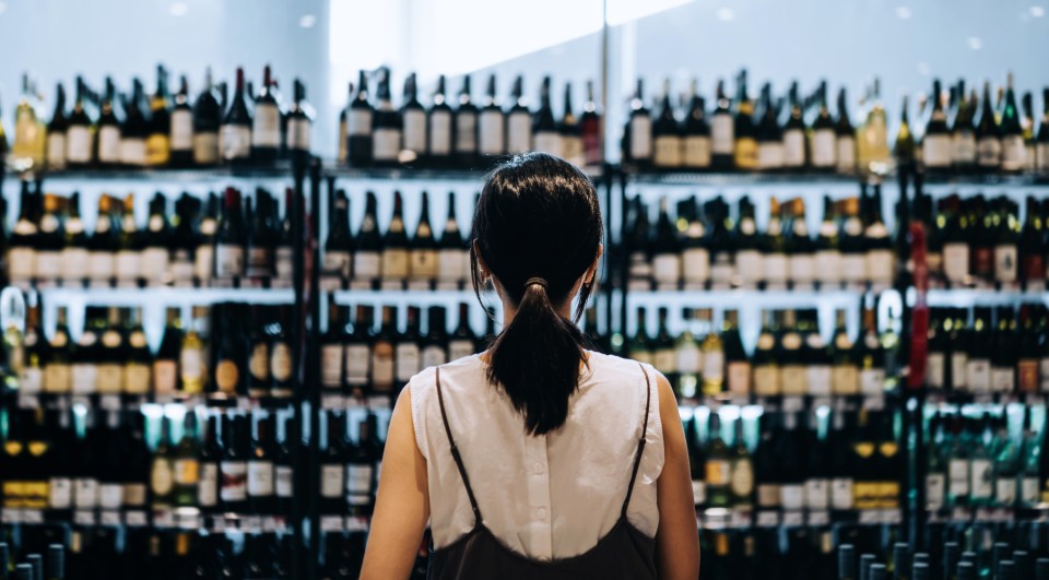 Woman looking at wine selection in a store.