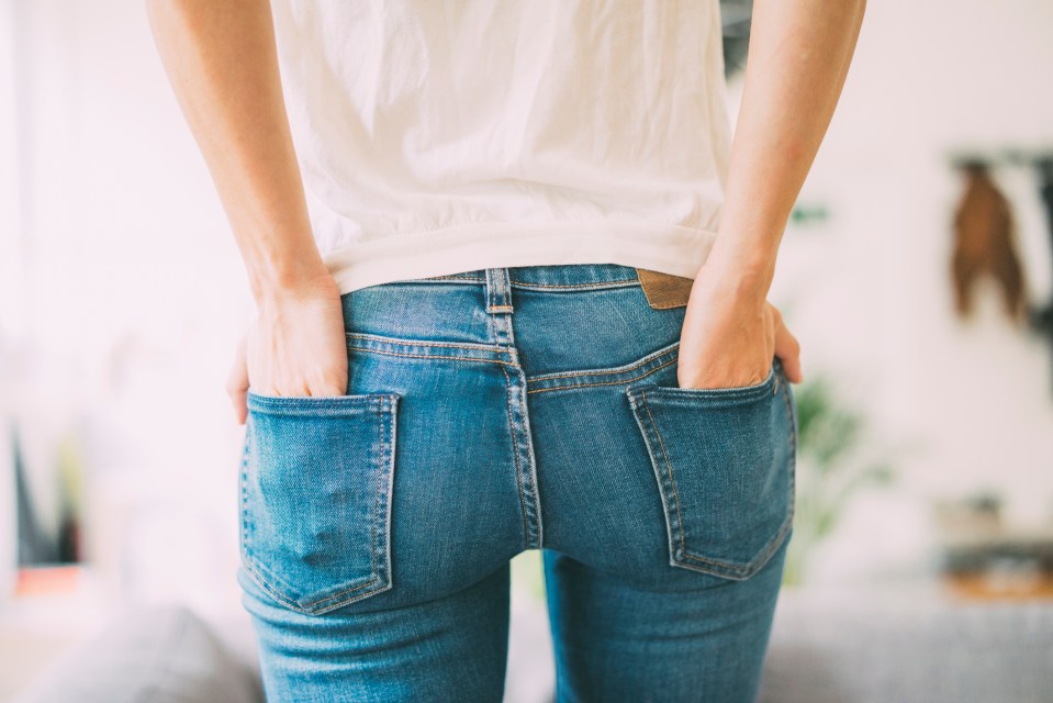 Rear view of a young woman in jeans.