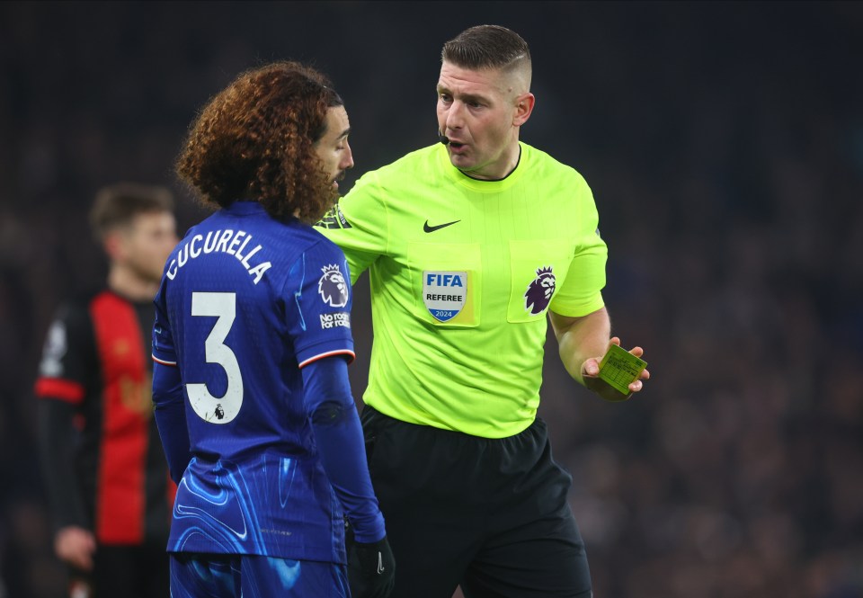 Referee showing a yellow card to Marc Cucurella.