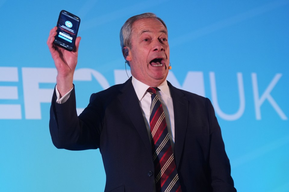 Nigel Farage shows a phone displaying Reform UK membership numbers at a conference.