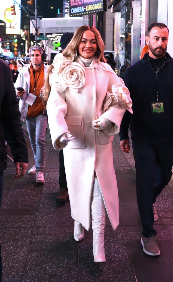 She was then seen wearing a white coat with a large floral corsage