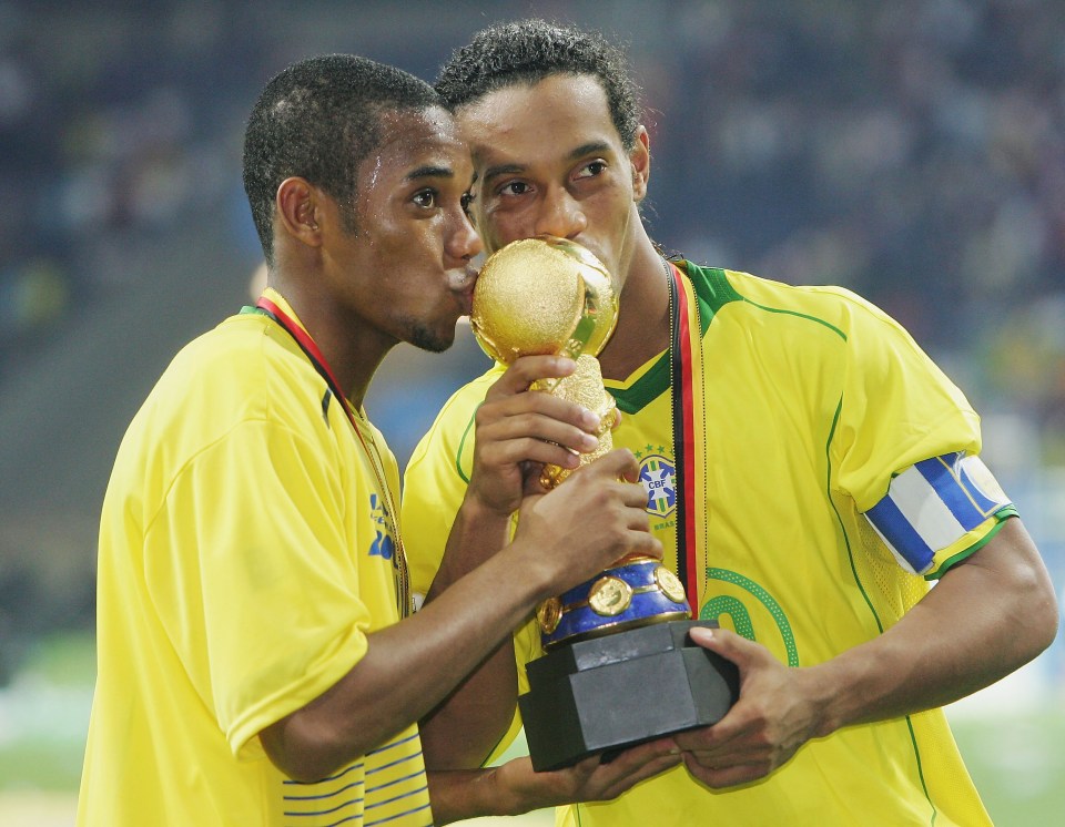 Robinho and Ronaldinho of Brazil kissing the Confederations Cup trophy.