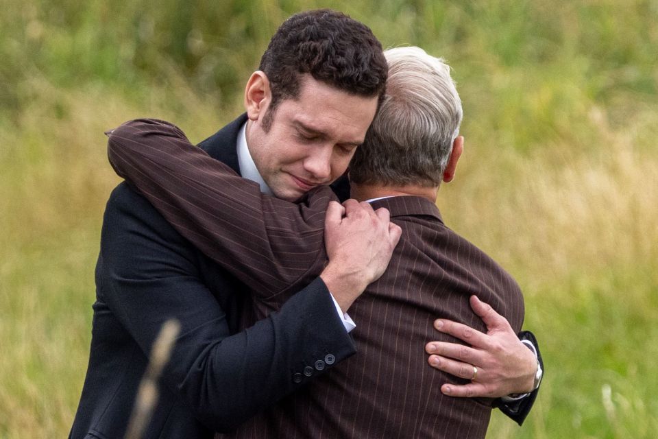 Tom Brittney and Robson Green embracing on the set of Grantchester.