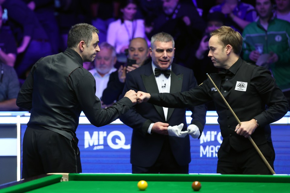 Ronnie O'Sullivan and Ali Carter shaking hands after a snooker match.