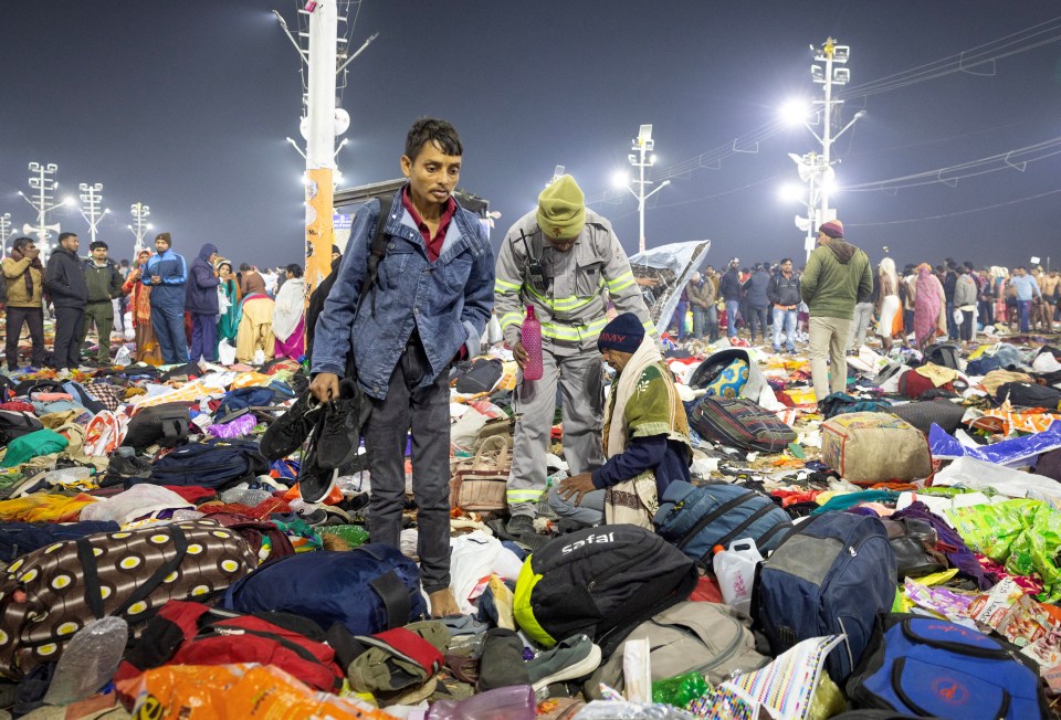 A policeman helps an injured person amidst scattered belongings after a stampede at the Maha Kumbh Mela in Prayagraj, India.