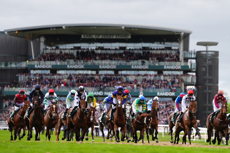 Horses and jockeys racing at Aintree Racecourse.