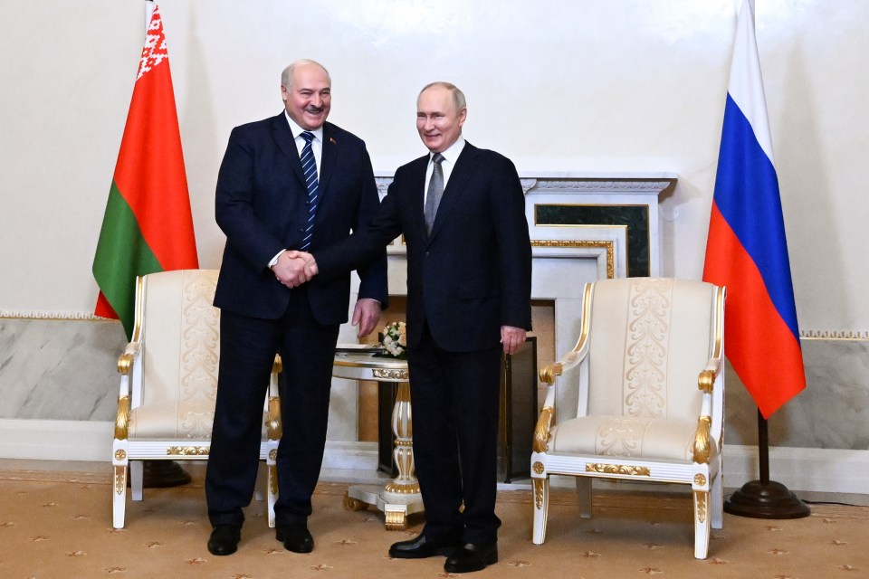 Vladimir Putin and Alexander Lukashenko shaking hands.