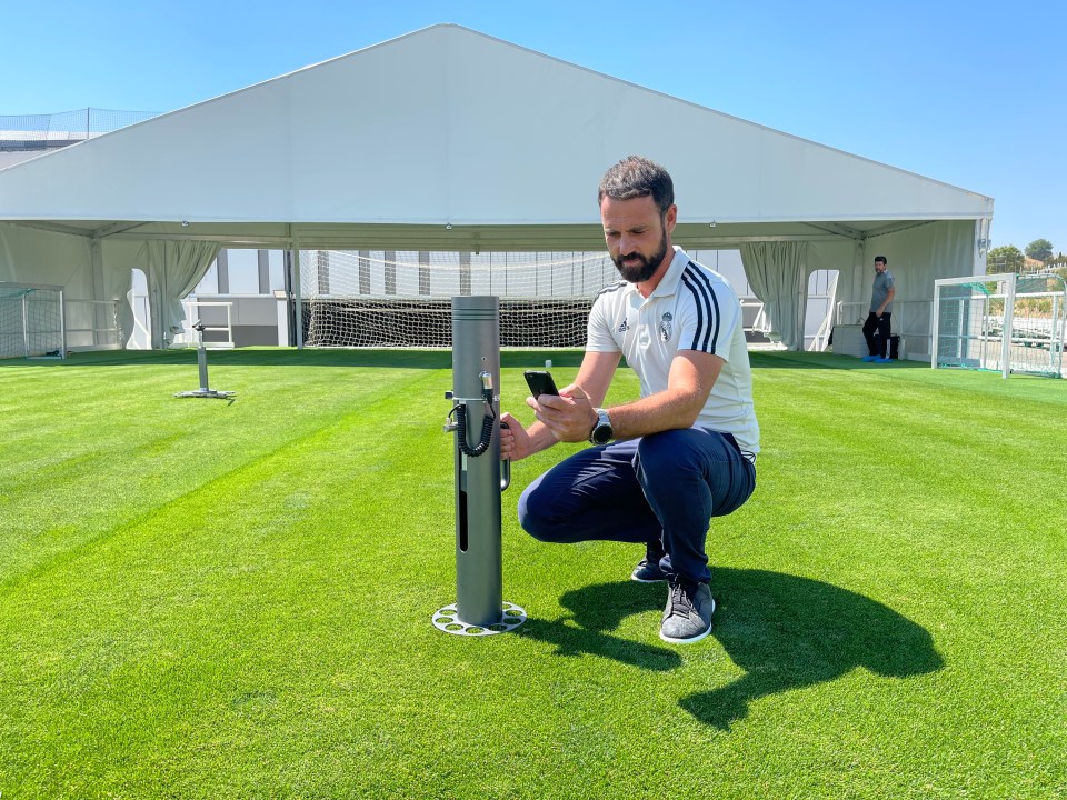 Grounds manager inspecting grass at Santiago Bernabéu Stadium.