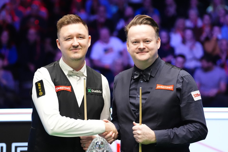 Shaun Murphy and Kyren Wilson shaking hands before a snooker match.