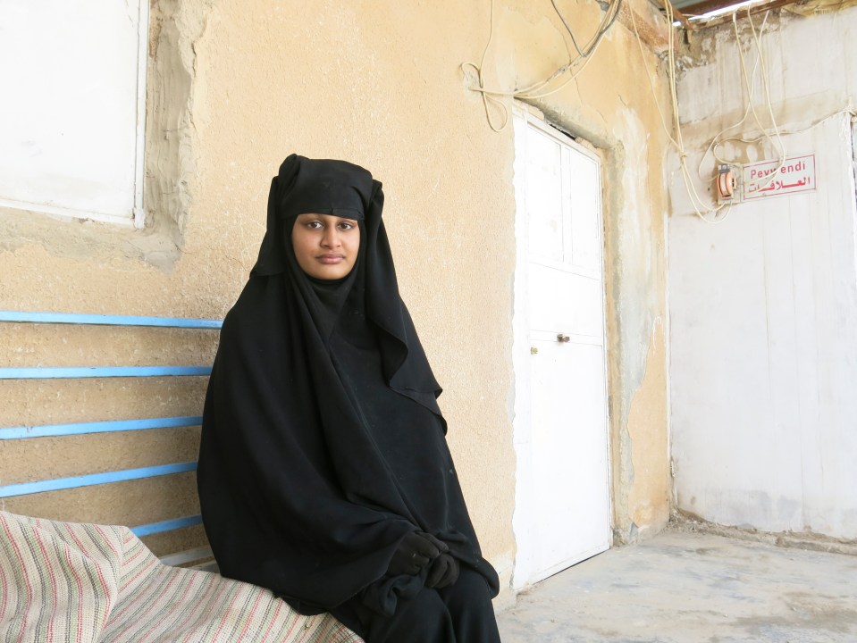 Shamima Begum, a young woman in a niqab, sits on a bench.