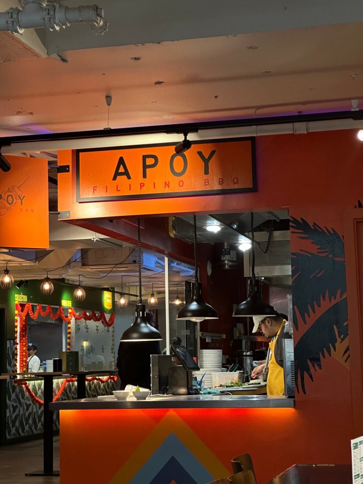 Apoy Filipino BBQ restaurant interior with a chef preparing food.