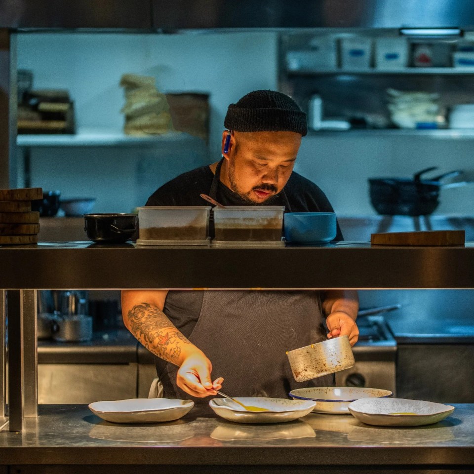 Chef plating food in a restaurant kitchen.