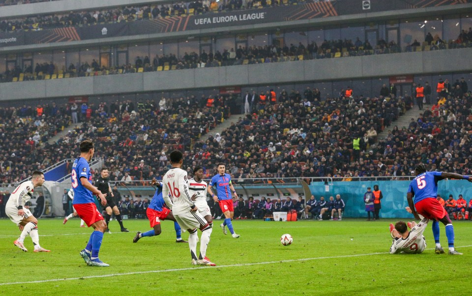 Manchester United player scoring a goal during a soccer match.