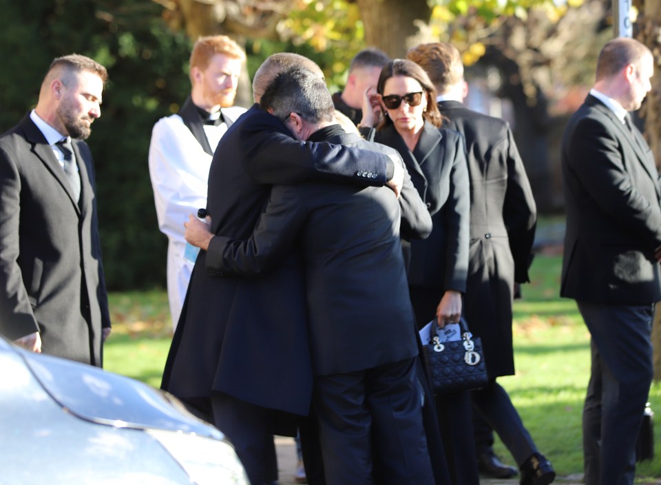 Simon Cowell hugging Liam Payne's parents at a funeral.