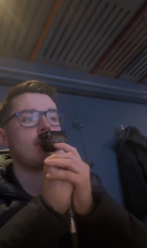 A man speaking into a microphone during a Sky Sports broadcast of the World Darts Championship.