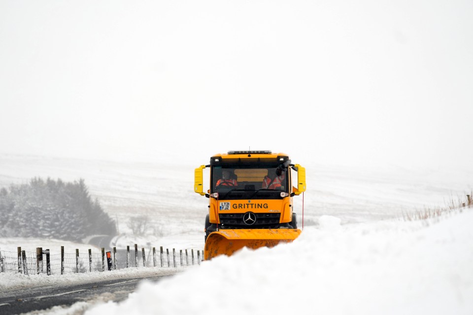 A snow plough and gritting lorry clears snow at Ribblehead in North Yorkshire