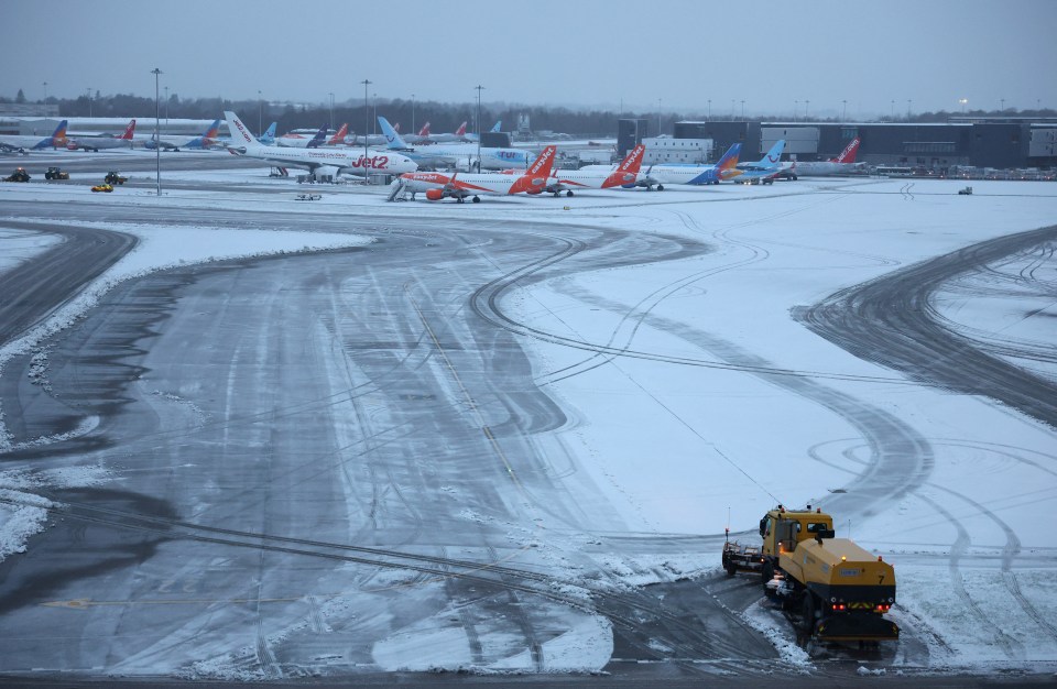 Snow plough clearing snow from Manchester Airport runway.