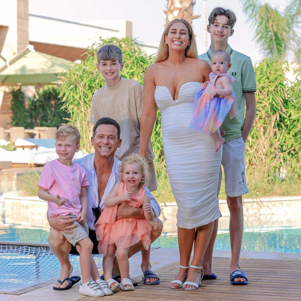 Family portrait of Stacey Solomon, Joe Swash, and their children by a pool.