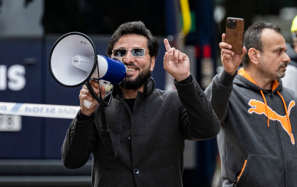 Man using a megaphone at a protest.