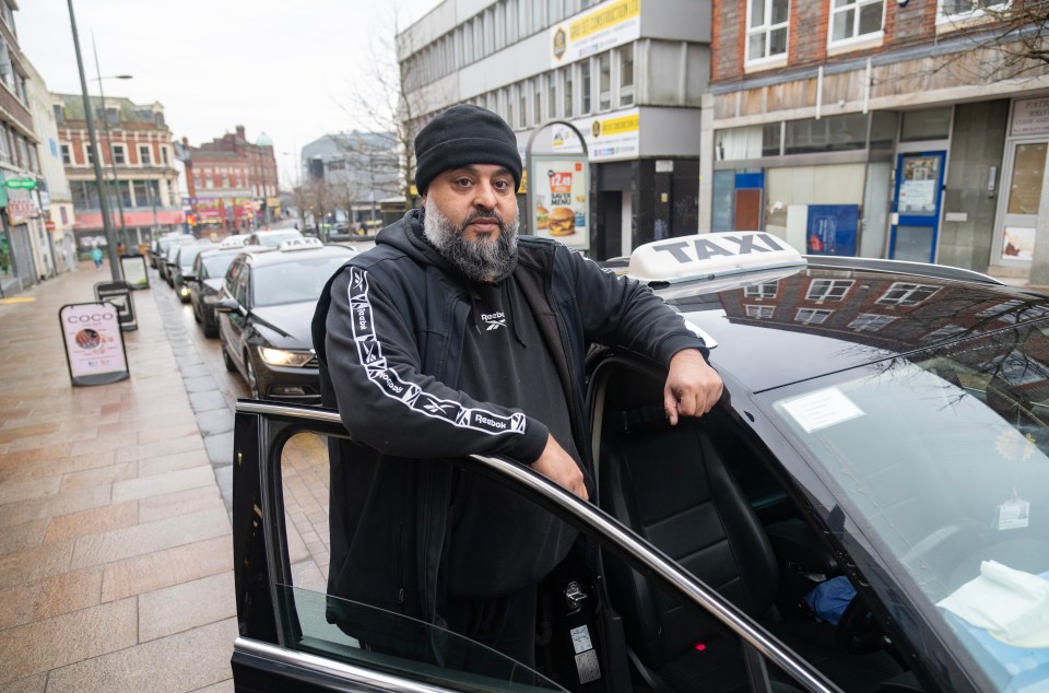 Taxi driver standing by his car.