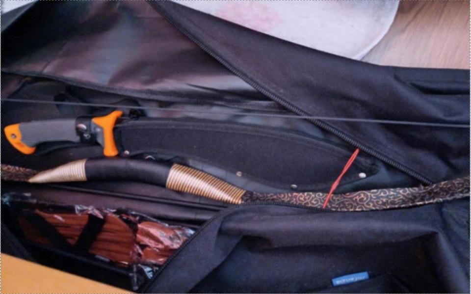 Close-up of a bag containing a knife and a curved weapon.