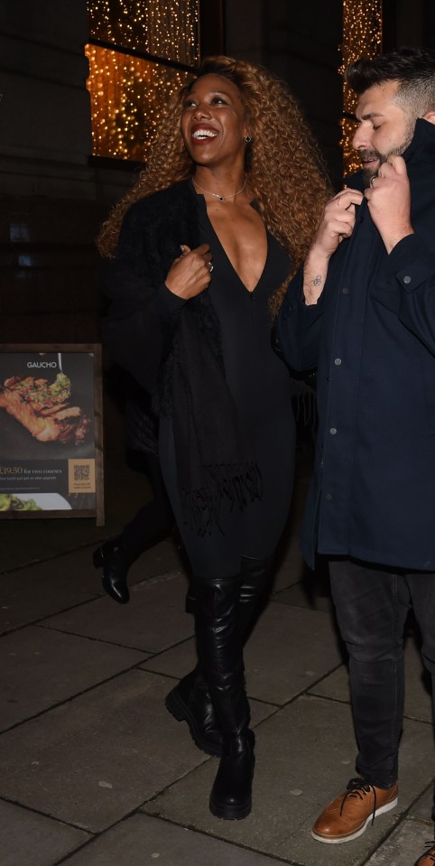 Two people outside a restaurant at night.