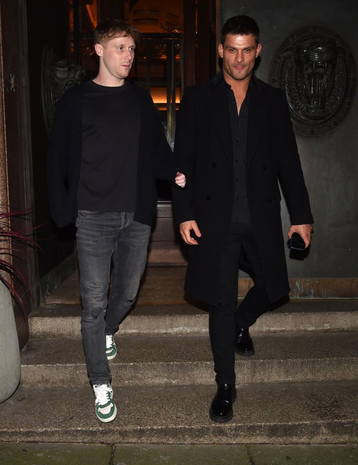 Two men in dark clothing walking down steps.