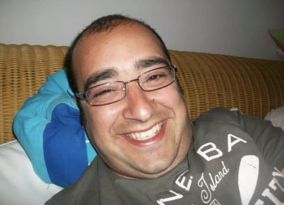 A smiling man wearing glasses.