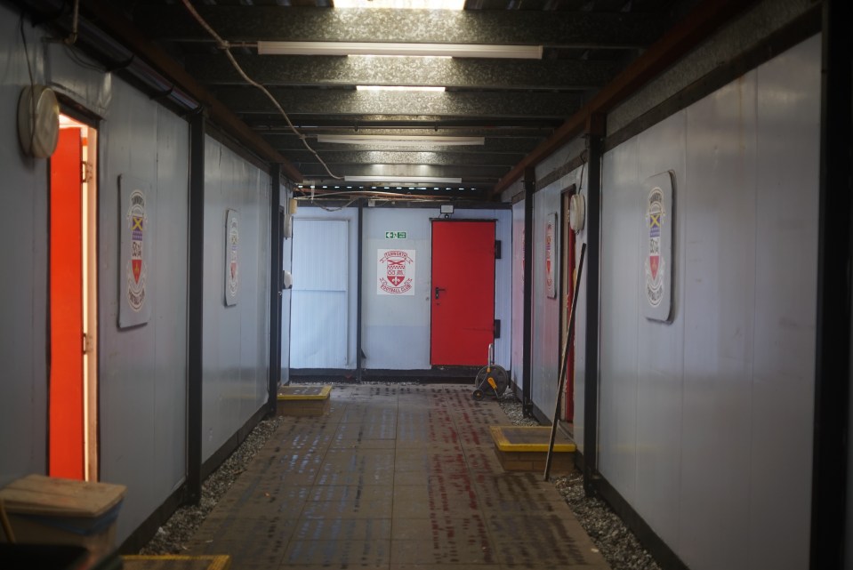 Interior hallway with red doors and Tamworth Football Club logos.