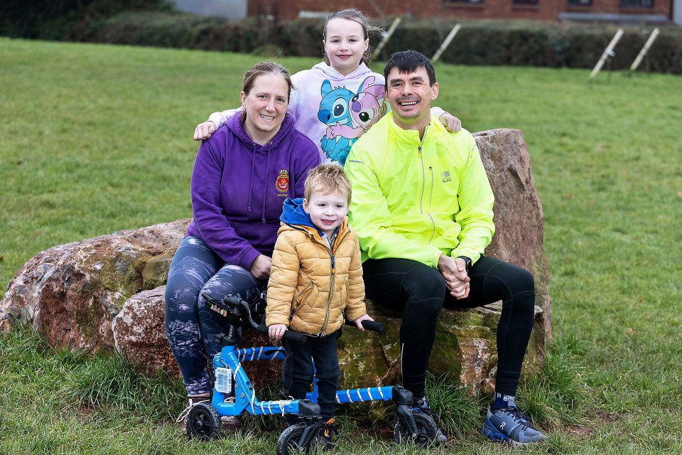 Family photo of parents and two children sitting on a rock.  The young boy has cerebral palsy.