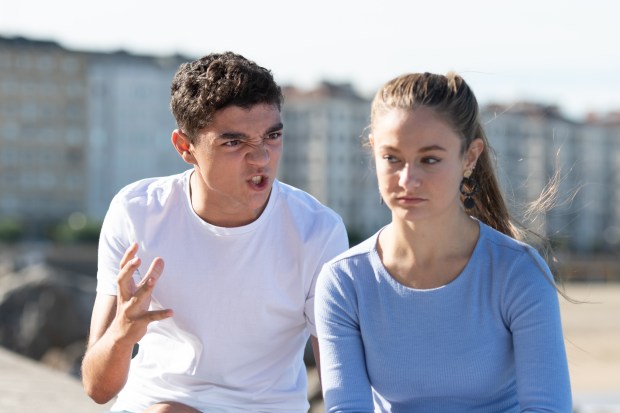 Angry teenage boy yelling at his upset girlfriend.