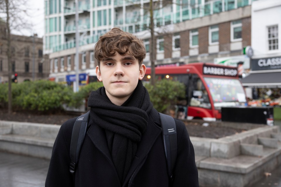 Portrait of a young man wearing a black coat and scarf.