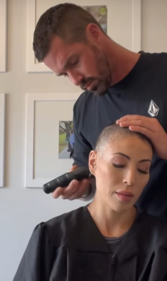 A man shaving a woman's head.