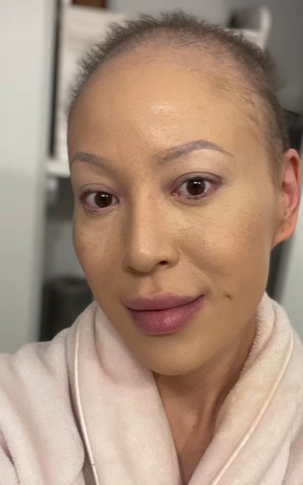 Close-up portrait of a woman with short hair, wearing makeup and a light-colored robe.