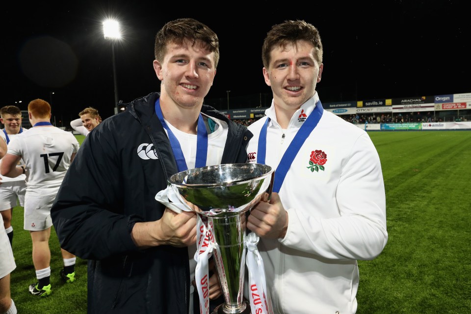 Tom and Ben Curry of England celebrating with a rugby trophy.