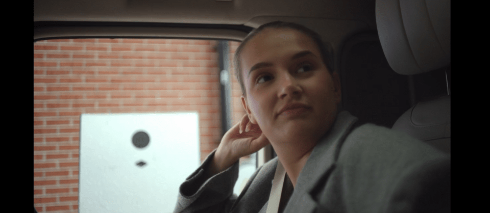 Woman sitting in a car, looking out the window.