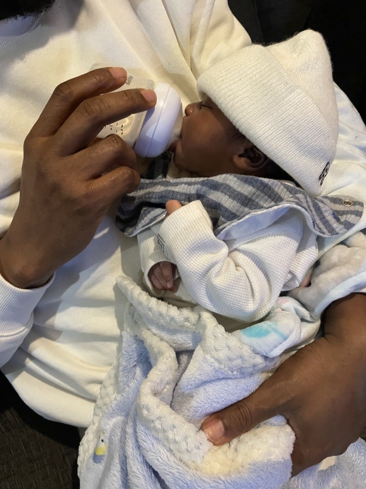 Father bottle-feeding his newborn son.