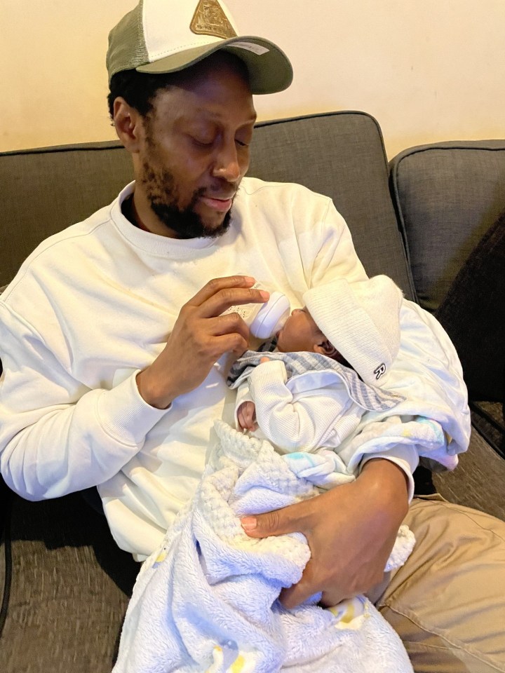 A father bottle-feeding his newborn son.