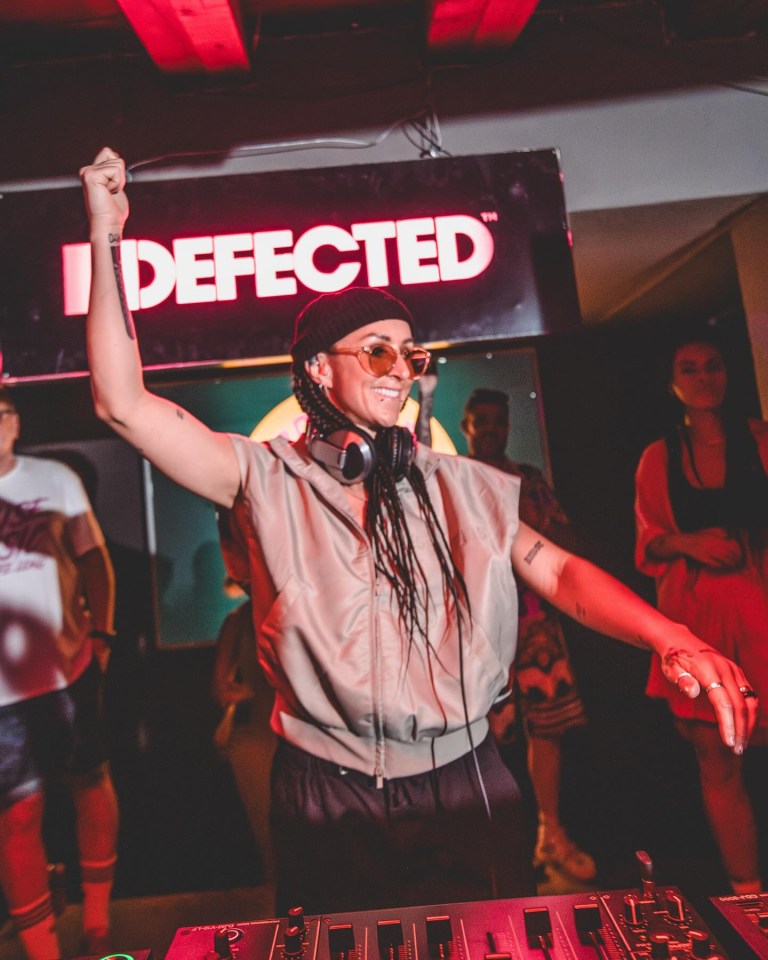 A female DJ performing at a Defected Records event.